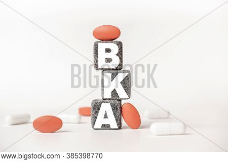 A Group Of White And Red Pills And Cubes With The Word Bka Below The Knee Amputation. On Them, White
