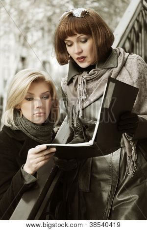 Two young businesswomen with a floder