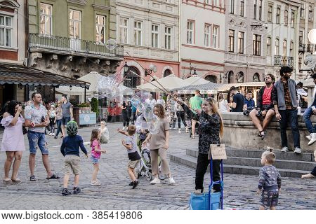 Lviv, Ukraine - September 12, 2020: Girl Make Performance With Huge Soap Bubbles For Kids In The Mar