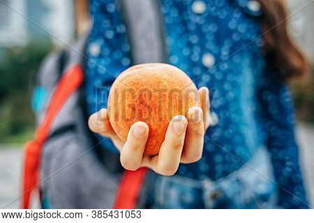 Healthy School Breakfast, Peach In The Hands Of A Schoolgirl