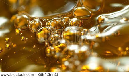 Macro shot of Splashing Oil on Golden Background