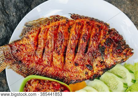 Delicious Grilled Tilapia (nila Bakar) From Indonesia With Rice, Tempeh, Vegetables, And Chilli Sauc