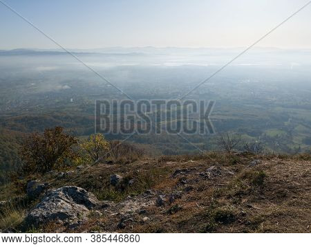 Scenic View From Kozara Mountain To The Valley Filled With Fog And Smoke During A Sunny Day.