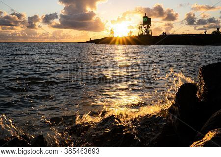 Green And Red Lighthouse Of The Harbor Entrance Of Stavoren, Netherlands, Photographed At Sunset And