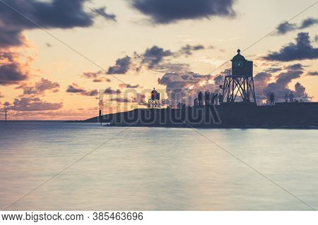 Green And Red Lighthouse Of The Harbor Entrance Of Stavoren, Netherlands, Photographed At Sunset And
