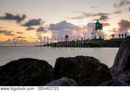 Green And Red Lighthouse Of The Harbor Entrance Of Stavoren, Netherlands, Photographed At Sunset And