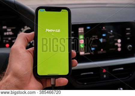 Closeup Mans Hand Holding Iphone With Mapy Cz Logo On The Screen And Apple Carplay On The Background