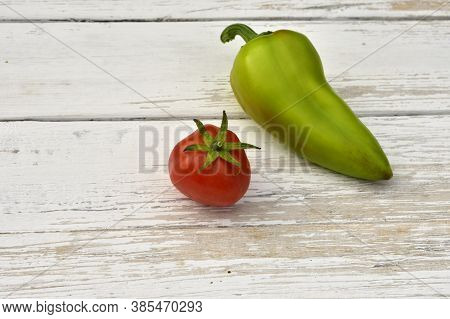 Red Tomato And Green Bell Pepper Pod On A Wooden Vintage Table