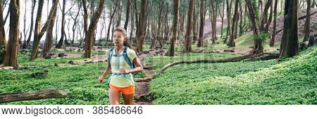 Trail ultra running runner athlete sprinting in forest panoramic. Sport sprinter active Asian girl doing high intensity interval training outdoors in summer banner landscape.