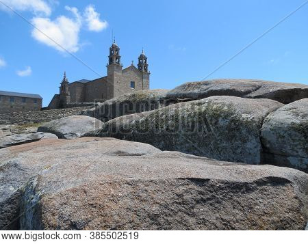 Church Virgen De La Barca Behind Huge Water Polished Ancient Sacral Stones On The Beach In Muxia, Sp