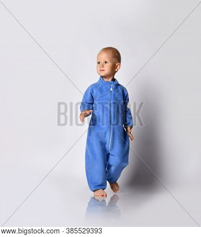 Full-growth Portrait Of Walking Going Towards Camera And Looking At Upper Corner Barefooted Baby Boy