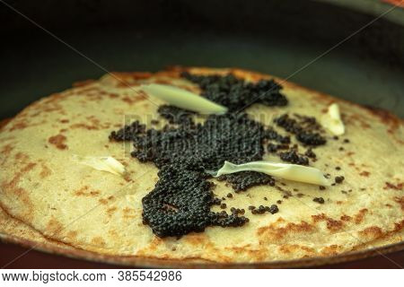 Black Caviar On A Pancake With Slices Of Butter