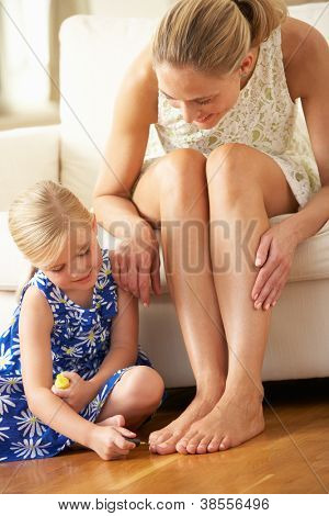 Filha pintura mãe dos pés em casa