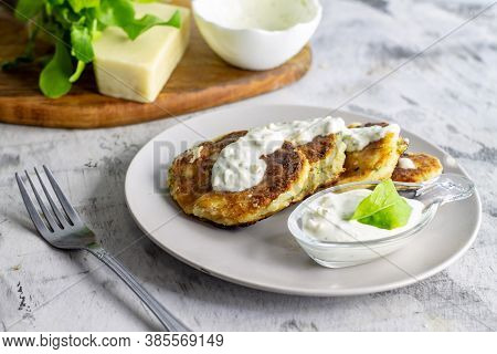 Unsweetened Cottage Cheese Pancakes With White Sauce On A Light Background