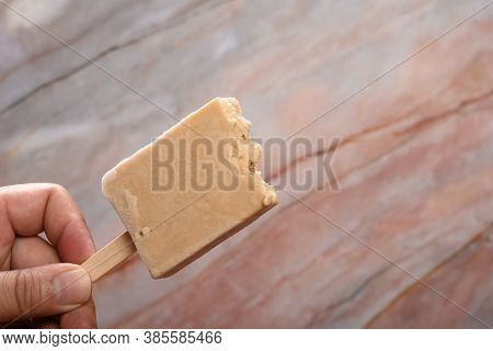 Hand Holding A Fresh Tapioca Milk Tea Flavor Popsicle With Couple Of Bites