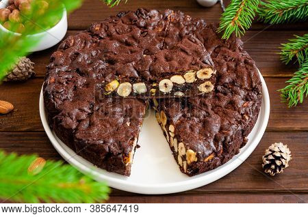 Panforte. Traditional Italian Christmas Dessert With Nuts And Dried Fruit On A White Plate On A Dark
