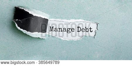 The Text Manage Debt Appearing Behind Torn Brown Paper