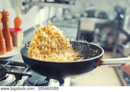 Onions And Bacon Tossed In A Pan Inside The Kitchen. Khichri Tossed In A Wok Pan