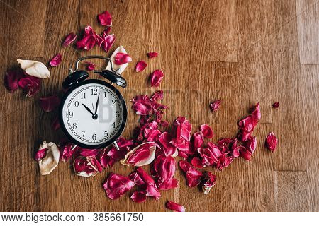Alarm Clock With Dried Petals.wilting Concept. Copy Space