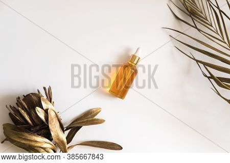 White, Orange And Black Serum Bottles On White Background. Trending Golden Branches Of Palm And Prot