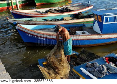 Caravelas, Bahia / Brazil - June 16, 2009: Fish Prepares The Net In The Port Of Fishing Boats On The