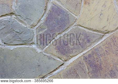 Natural Textured Background Of Flagstone Stone Wall With Rough Wide Cement Joints