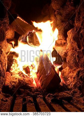 Beautiful Red Fire From Slice Wood, Dark Grey Black Coals Inside Metal Brazier. Wood Burning In The 
