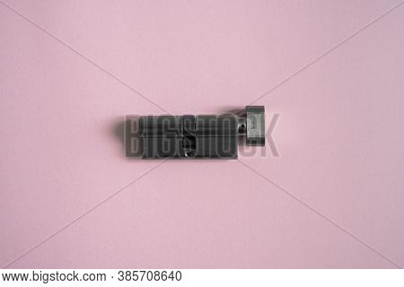 A Door Lock Cylinder Core On The Pink Background. The Cylinder Of The Lock. Installing A New Lock On