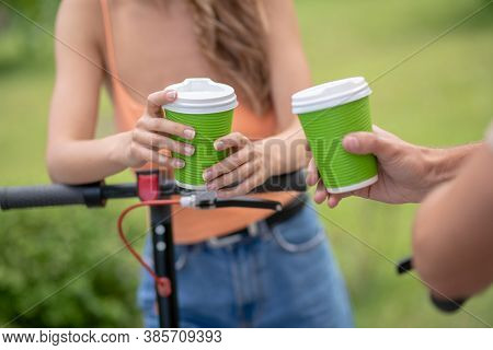 Close Up Picture Of Two People With Coffee Cups