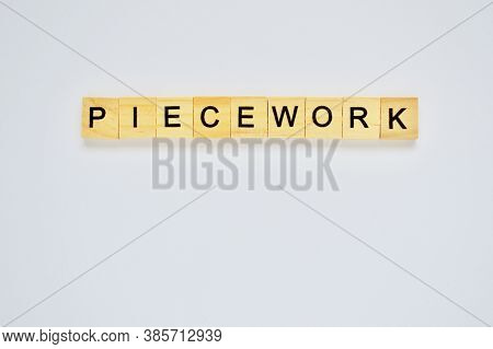 Word Piecework. Wooden Blocks With Lettering On Top Of White Background. Top View Of Wooden Blocks W