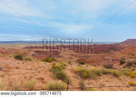Utah Rural Landscape Of Flat Land With Red Rock Outcrop In Foreground.