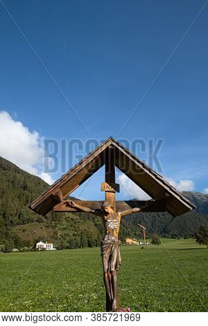 Mustair, Switzerland - September 8, 2020: Roadside Sign Of The Cross In Mustair