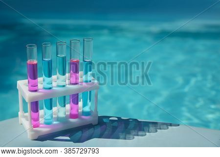 Test Tubes With Reagents In Rack Near Swimming Pool. Space For Text