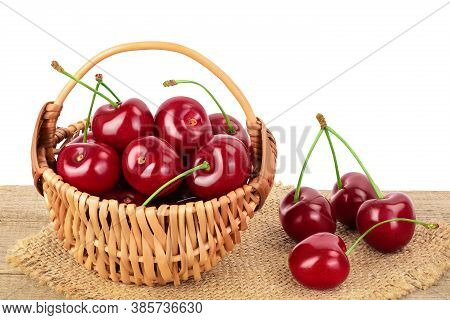 Red Sweet Cherry In A Wicker Basket On Wooden Table Isolated On White Background With Clipping Path 