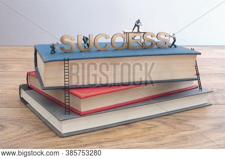 Miniature Construction Builders Working Around The Text Heading Succcess On A Stack Of Books