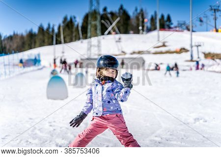 Young Happy Skier Girl Throwing Snowballs In Snowball Fight. Young Skier Having Fun On Ski Slope, Bi