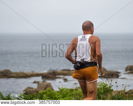 Muxía, A Coruña, Spain; 08/17/2020: Detail Of A Runner Training With The Sea In The Background