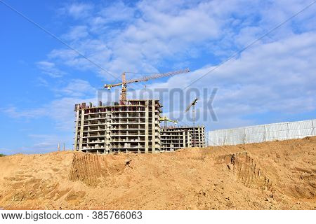 Preparing To Pour A Bucket Of Concrete Into Formwork.tower Crane Lifting Cement Bucket During Constr