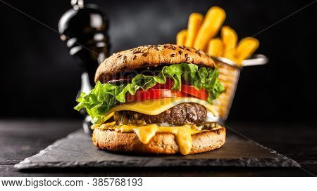 Tasty Humburger With Tomatoes And Cheese. Rustic Stone Background. Front View.
