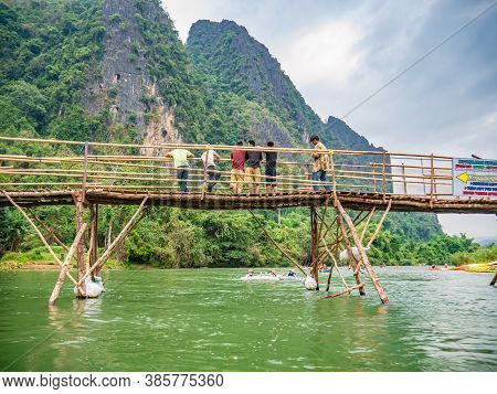 Vangvieng/lao-10 Dec 2017:unacquainted People On The Wooden Bridge And Kayaking At Namsong River Van