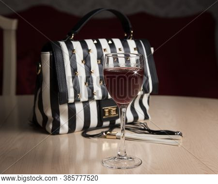 Black And White Bag And Glass Of Red Wine On The Table, Modern Life Style Concept