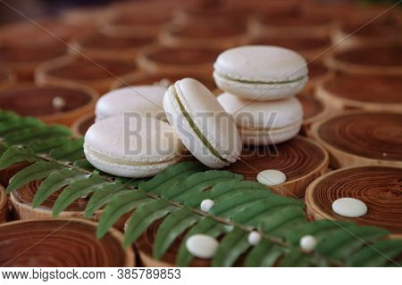 White Delicate Lowly Macaroons On A Wooden Background. The Pastel Tone Of The Cream Inside The Frenc