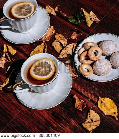 Two White Ceramic Cups With Beautiful Gold Shiny Handles With Tea And Lemon. Snacks And Sweets For T