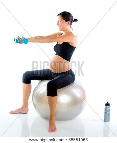 Bella donna incinta in palestra con manubri su palla aerobica