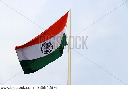 Tri Color Of Indian Flag, Orange White And Green Color With Blue Dhamma Wheel At Center On Sky Backg