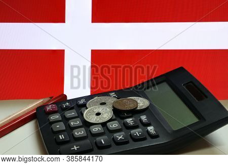Heap Of Denmark Coins On Calculator With Red And Wooden Pencil On White Floor And Danish Nation Flag