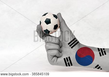 Mini Ball Of Football In South Korea Flag Painted Hand, Hold It With Two Finger On White Background.