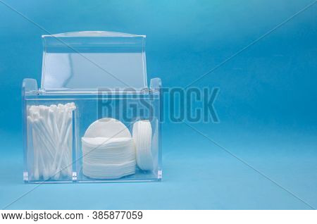 Organizer With The Lid Open With White Cotton Pads And Cotton Swabs On A Blue Background With Copy S