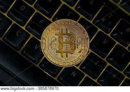 Bitcoin On Compuer Keyboard In Background, Symbol Of Electronic Virtual Money And Mining Cryptocurre