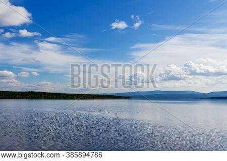 Pacifying Lake Landscape On Summer Sunny Day. Blue Mountains Silhouette , Green Forest And White Clo